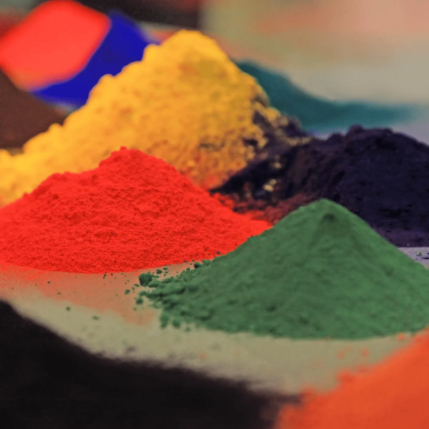 Piles of red, yellow, green and blue powder coating pigment showing the colour range